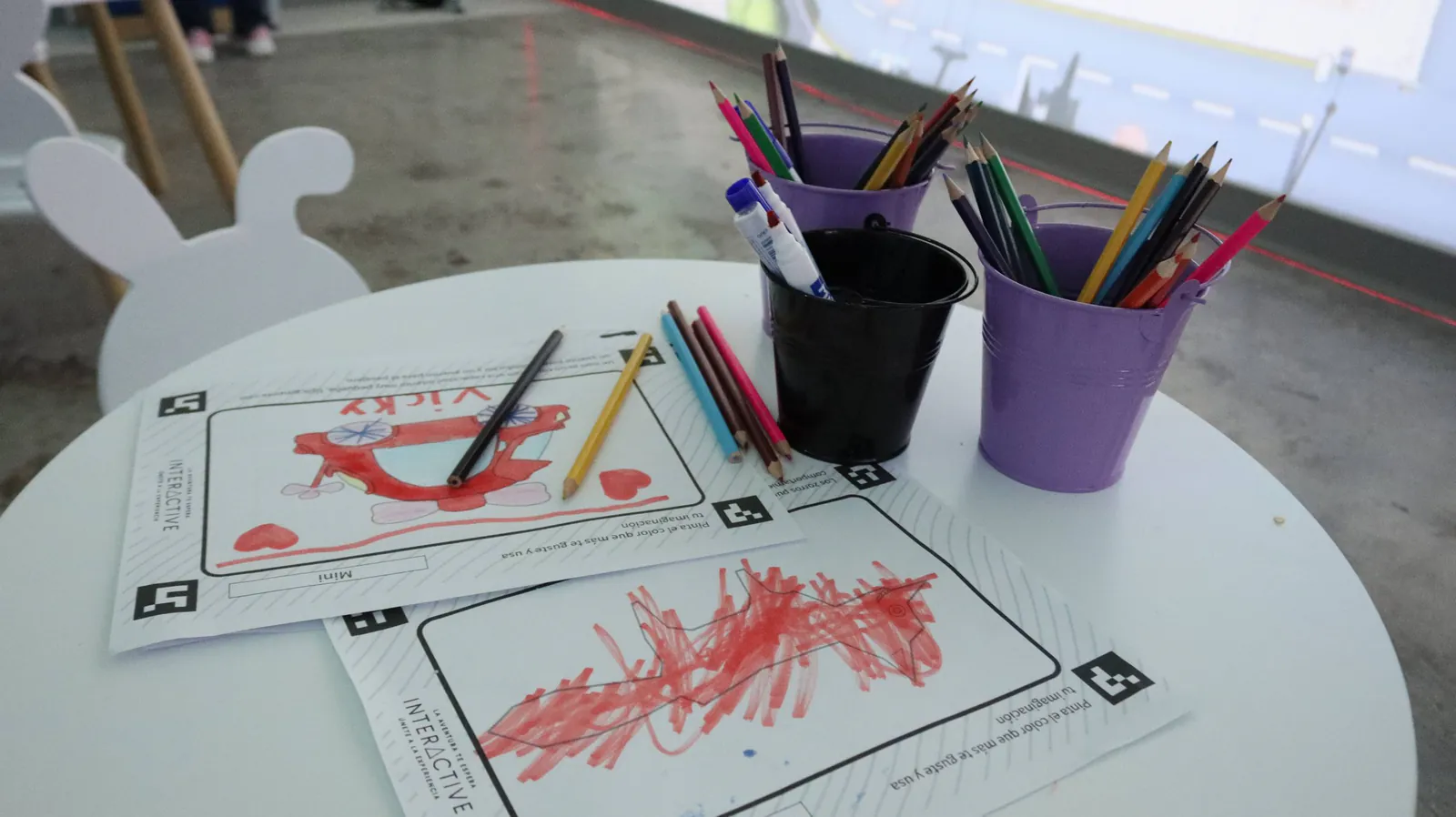 Mesa de dibujo con lápices de color y hojas coloreadas